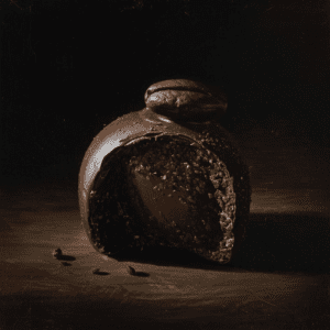 Produktbillede af en mørk chokolade trøffel med kaffe-ganache fyld og toppet med en enkel kaffebønne