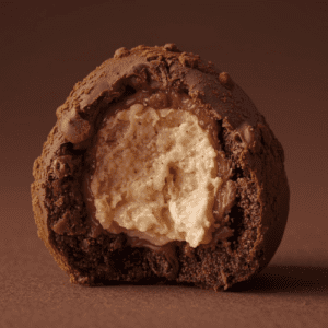 Produktbillede af en mælkechokolade trøffel med brownie og hasselnødde-praliné fyld indeni