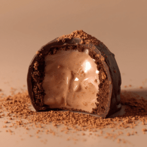 Produktbillede af en mælkechokolade trøffel med flydende chai-latte creme og pulver-chai drysset henover